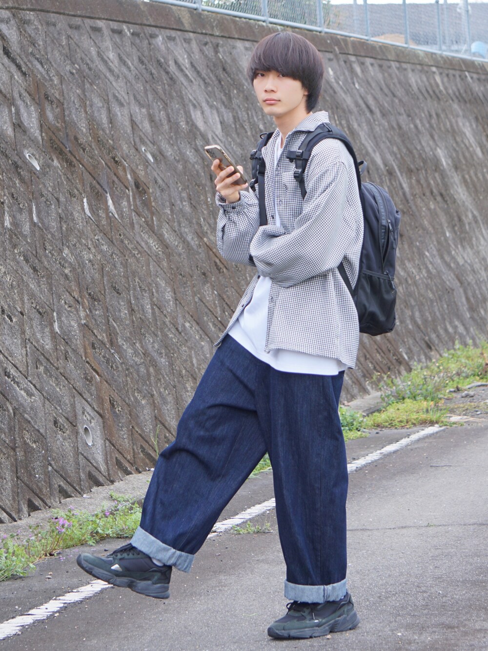 ブルー系のデニムパンツ、ブラック系のスニーカー、ホワイト系のシャツ/ブラウスを着用したメンズの春コーディネートの2枚目の写真