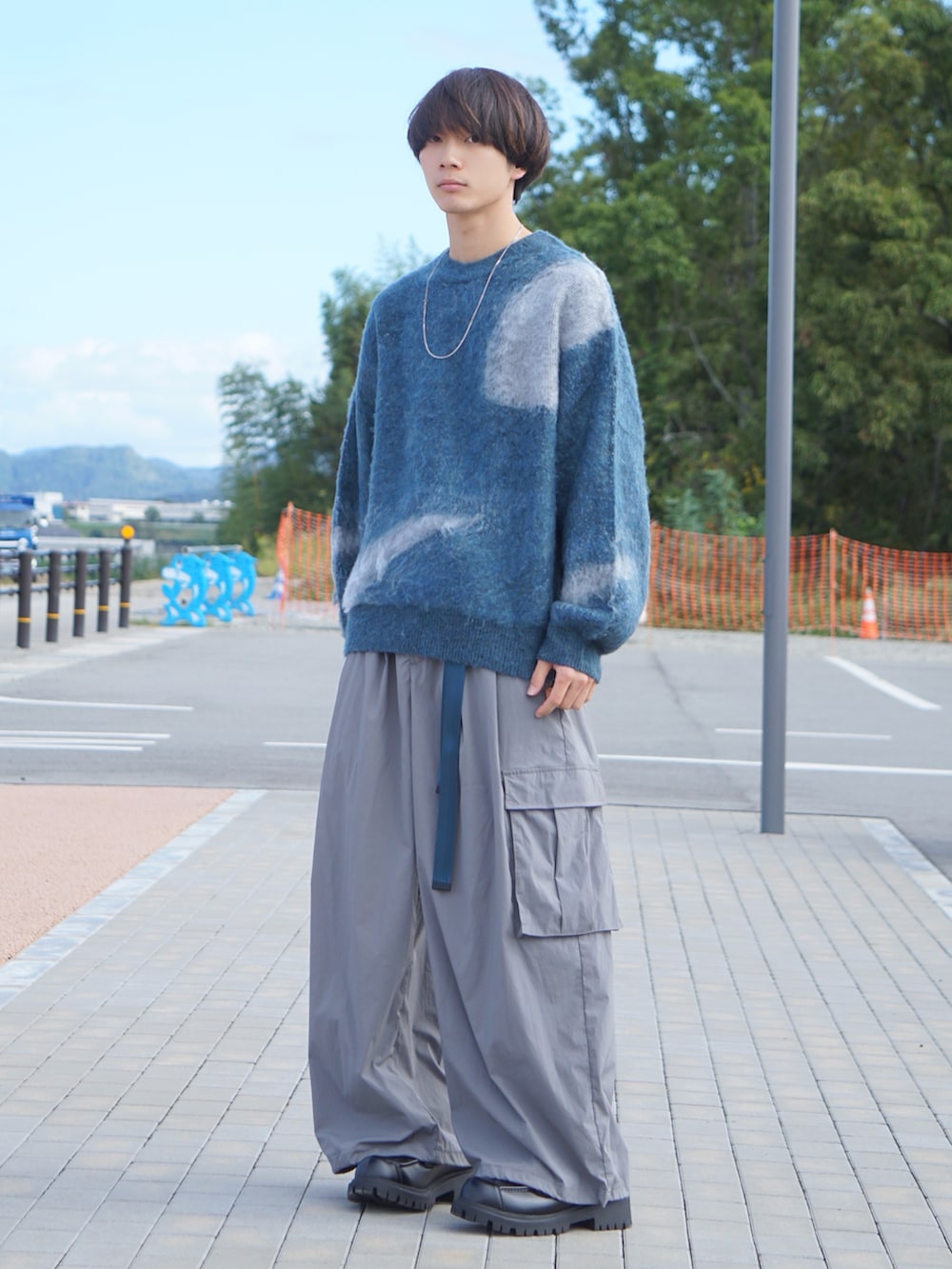 ブルー系のニット/セーター、グレー系のカーゴパンツ、ブラック系のローファーを着用したメンズの秋コーディネートの2枚目の写真