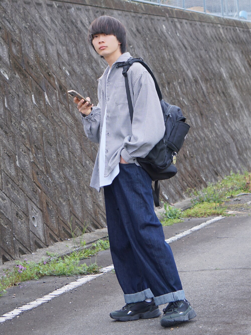 ブルー系のデニムパンツ、ブラック系のスニーカー、ホワイト系のシャツ/ブラウスを着用したメンズの春コーディネートの3枚目の写真