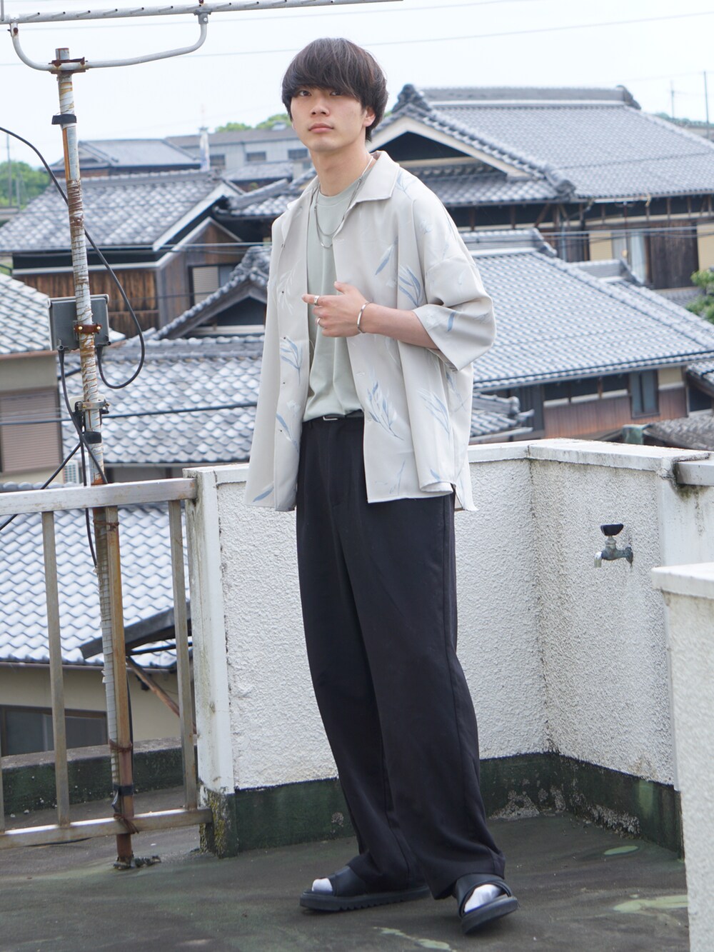 ブラック系のその他パンツ、グリーン系のTシャツ/カットソー、ホワイト系のシャツ/ブラウスを着用したメンズの春コーディネートの2枚目の写真
