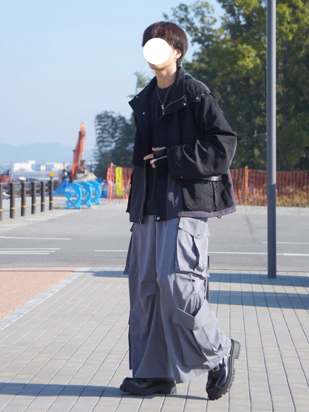 ブラック系のマウンテンパーカー、グレー系のカーゴパンツ、ブラック系のローファーを着用したメンズの秋コーディネートの2枚目の写真