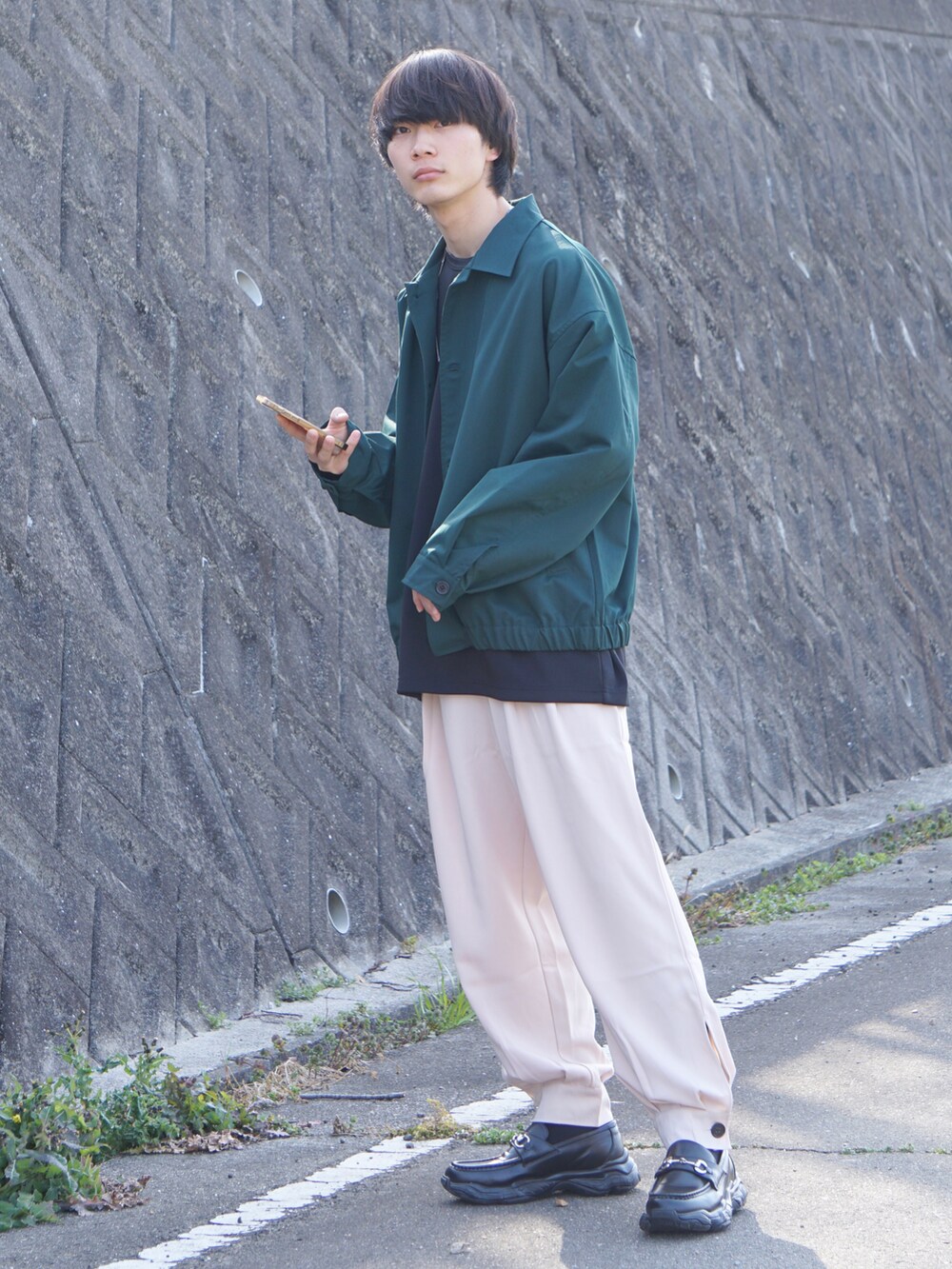 グリーン系のその他アウター、ブラック系のTシャツ/カットソー、ベージュ系のその他パンツを着用したメンズの春コーディネートの2枚目の写真
