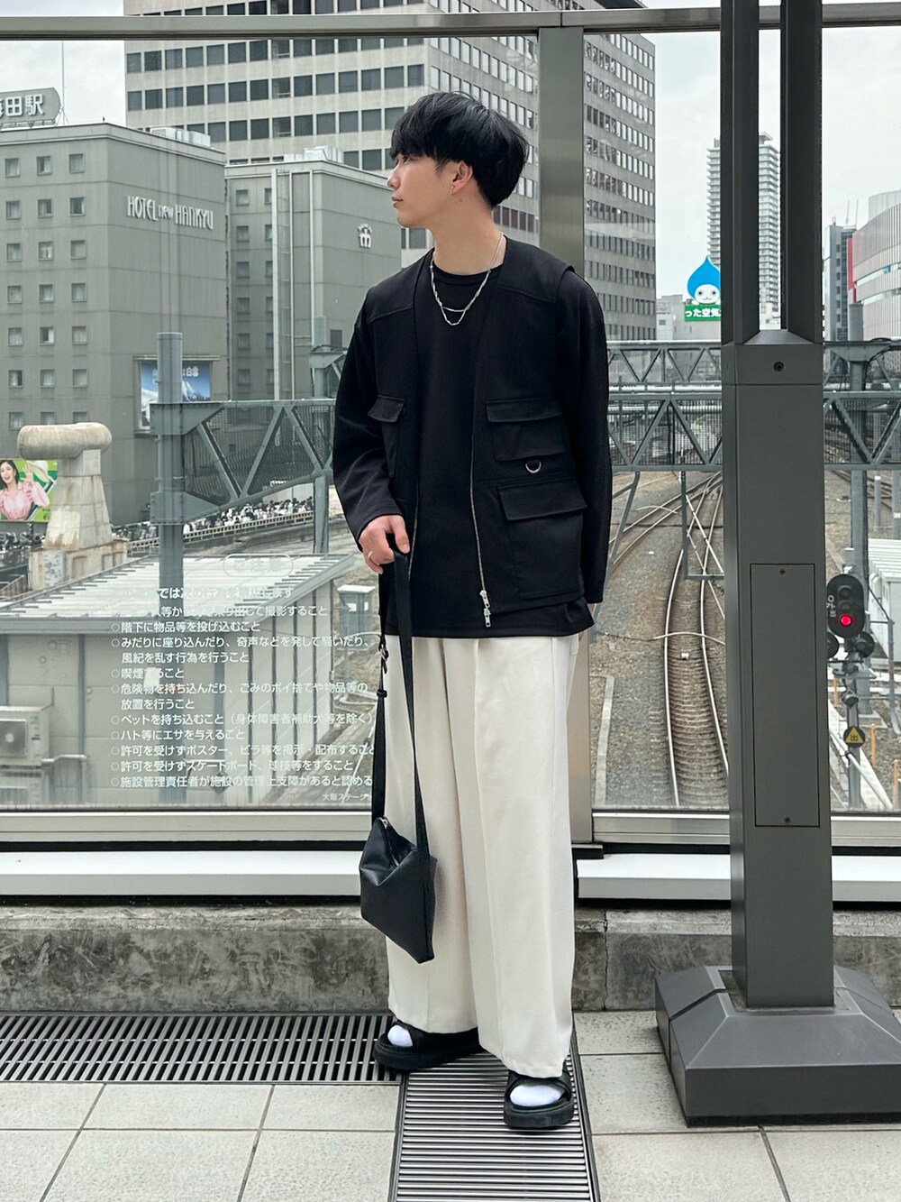 ブラック系のサンダル、ブラック系のTシャツ/カットソー、ブラック系のベストを着用したメンズの春コーディネートの2枚目の写真