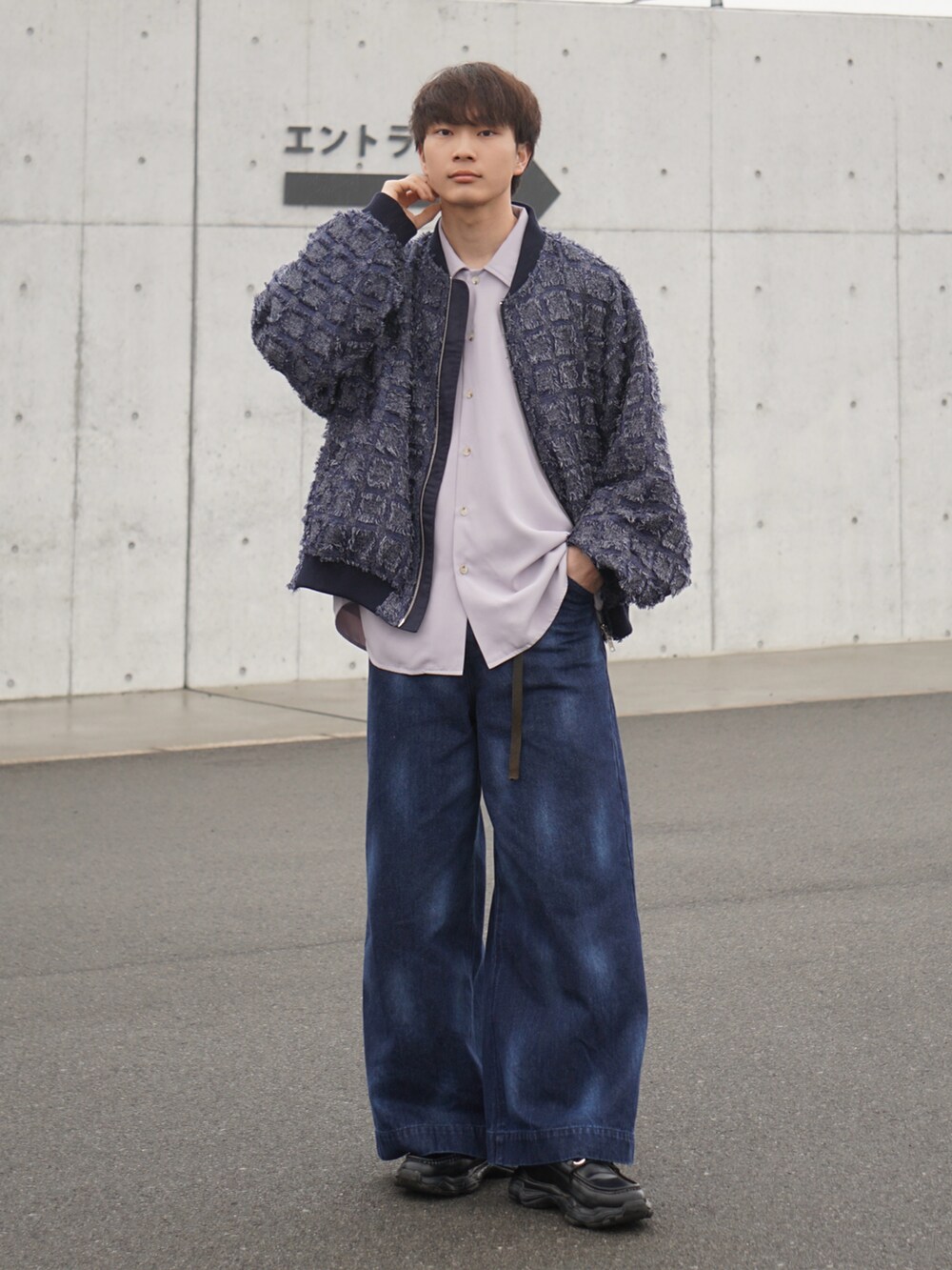 ブルー系のブルゾン、ブルー系のデニムパンツ、ブラック系のスニーカーを着用したメンズの冬コーディネートの2枚目の写真