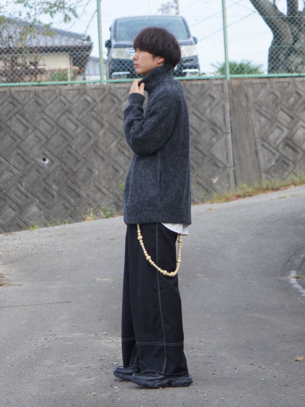 ブラック系のニット/セーター、ホワイト系のシャツ/ブラウス、ブラック系のスラックスを着用したメンズの秋コーディネートの2枚目の写真