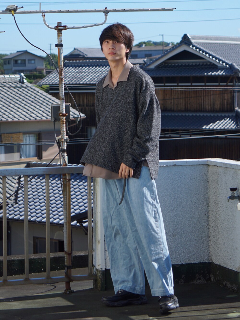 ブラック系のスウェット、ベージュ系のシャツ/ブラウス、ブルー系のデニムパンツを着用したメンズの秋コーディネートの2枚目の写真