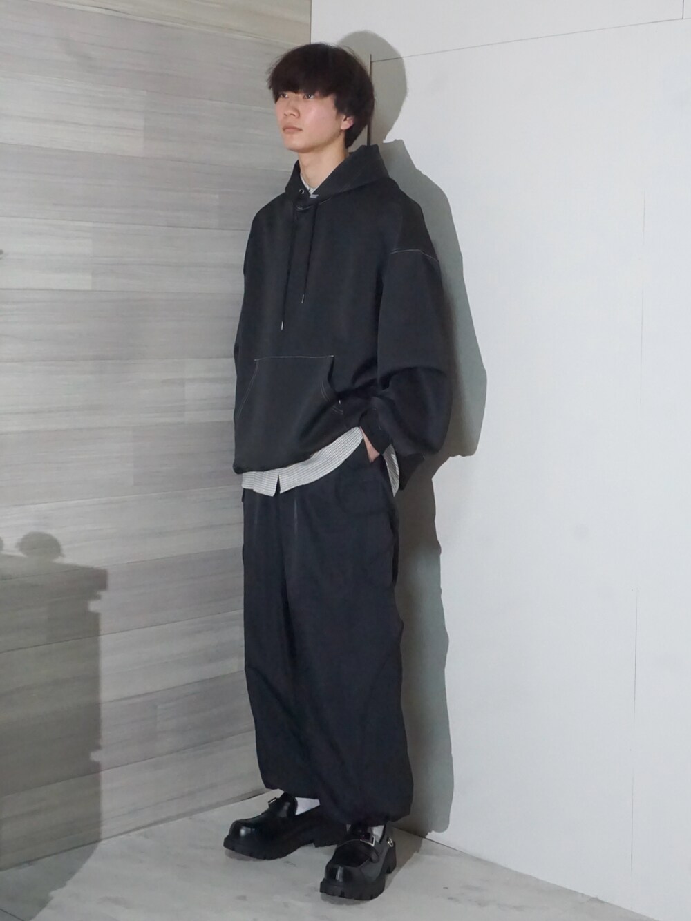 ブラック系のパーカー、ホワイト系のシャツ/ブラウス、ブラック系のパンツを着用したメンズの冬コーディネートの2枚目の写真