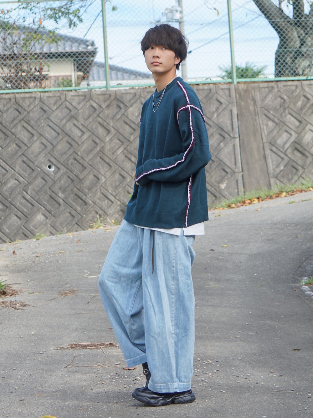 ブルー系のニット/セーター、ブルー系のデニムパンツを着用したメンズの秋コーディネートの2枚目の写真
