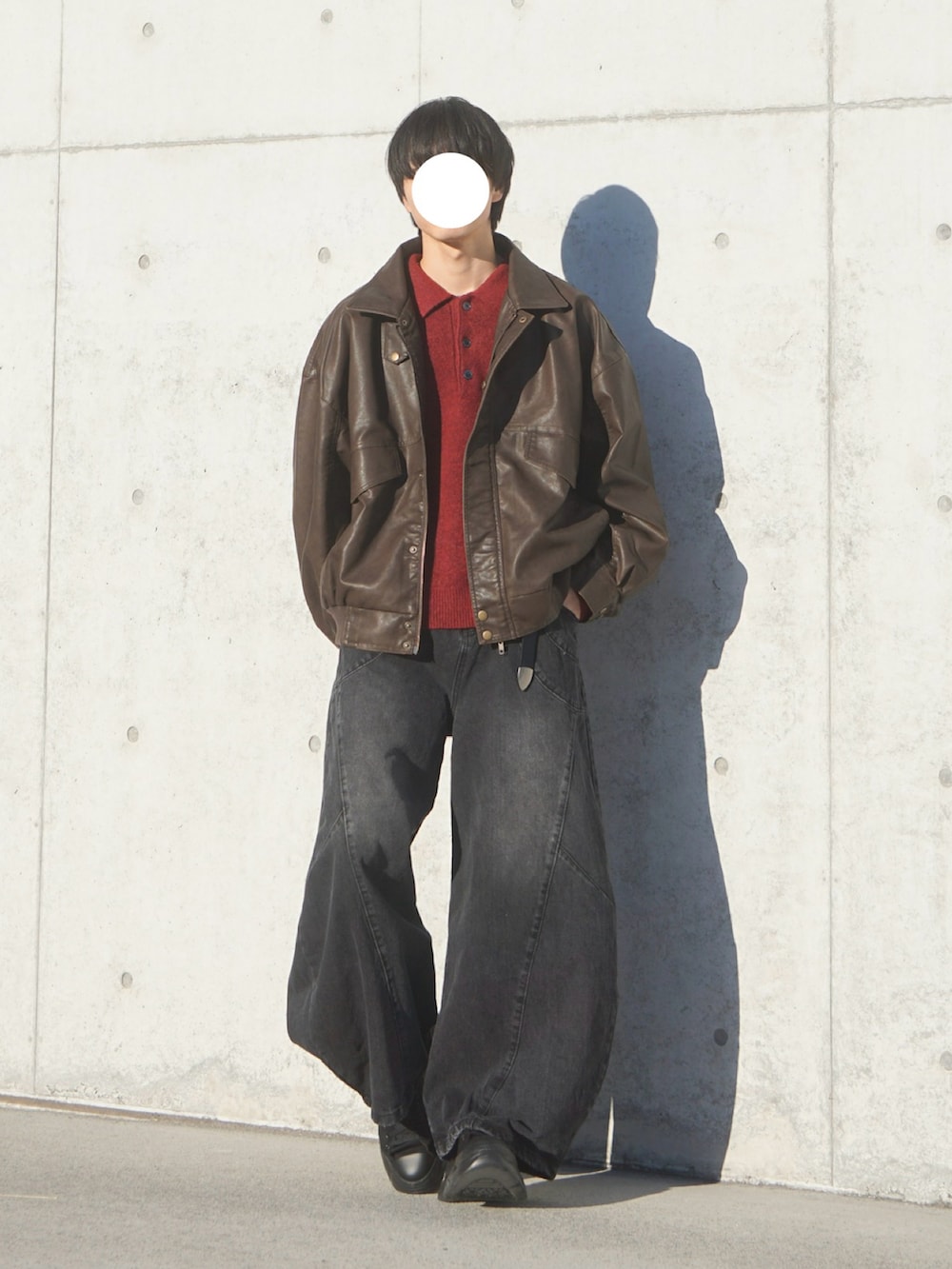 ブラウン系のブルゾン、ブラック系のデニムパンツ、レッド系のポロシャツを着用したメンズの冬コーディネートの2枚目の写真