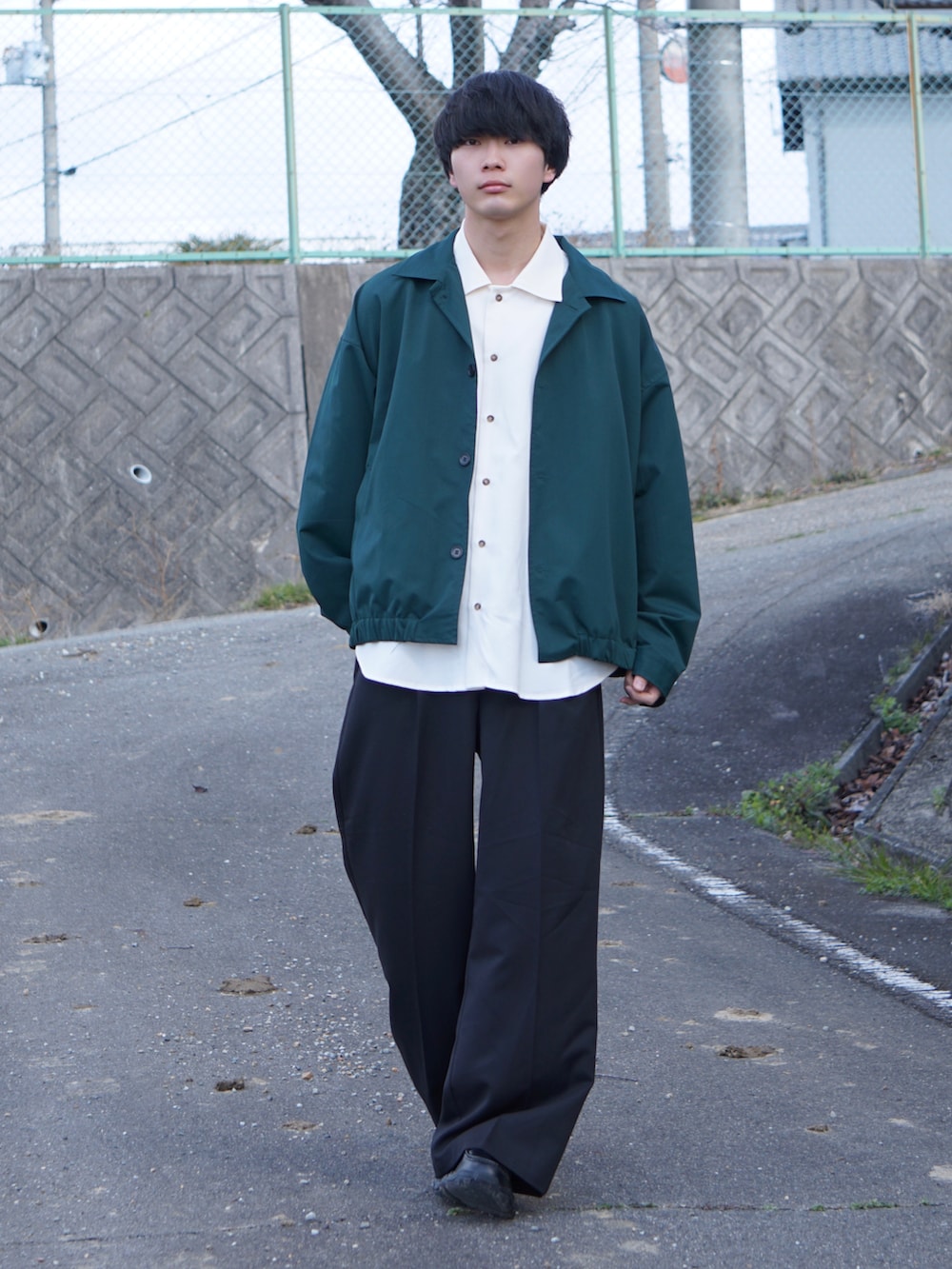 グリーン系のその他アウター、ホワイト系のシャツ/ブラウス、ブラック系のスラックスを着用したメンズの春コーディネートの2枚目の写真