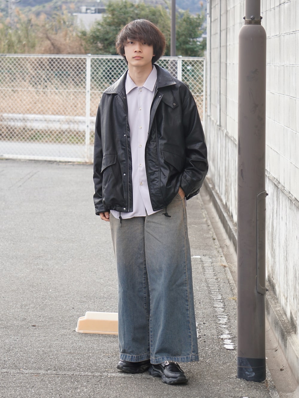 ブラック系のブルゾン、ブルー系のデニムパンツ、ブラック系のスニーカーを着用したメンズの冬コーディネートの2枚目の写真