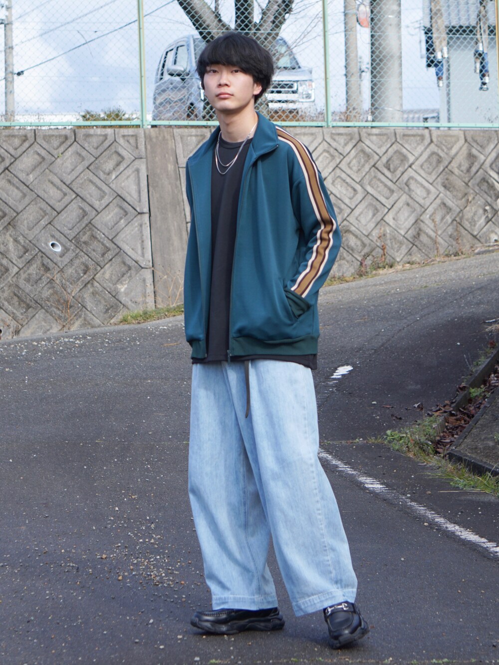 グリーン系のブルゾン、ブラック系のTシャツ/カットソー、ブルー系のデニムパンツを着用したメンズの冬コーディネートの3枚目の写真