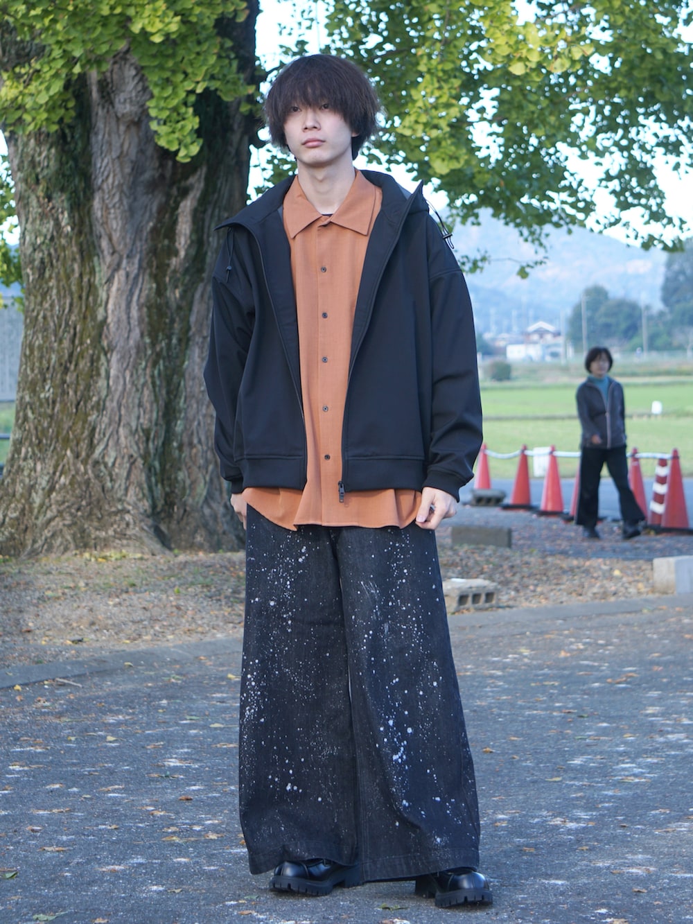 ブラック系のパーカー、オレンジ系のシャツ/ブラウス、ブラック系のデニムパンツを着用したメンズの秋コーディネートの2枚目の写真