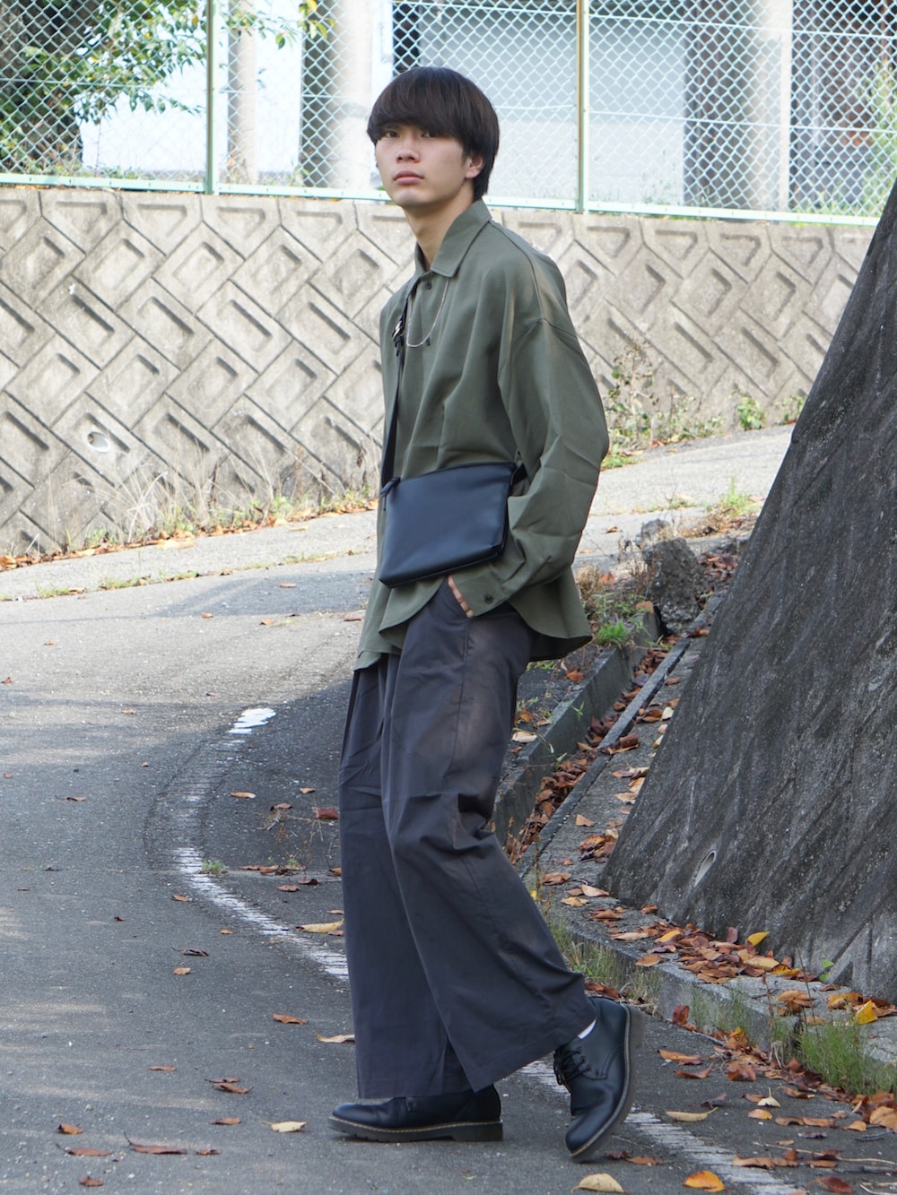 グレー系のその他パンツ、ブラック系のショルダーバッグ、グリーン系のシャツ/ブラウスを着用したメンズの夏コーディネートの2枚目の写真