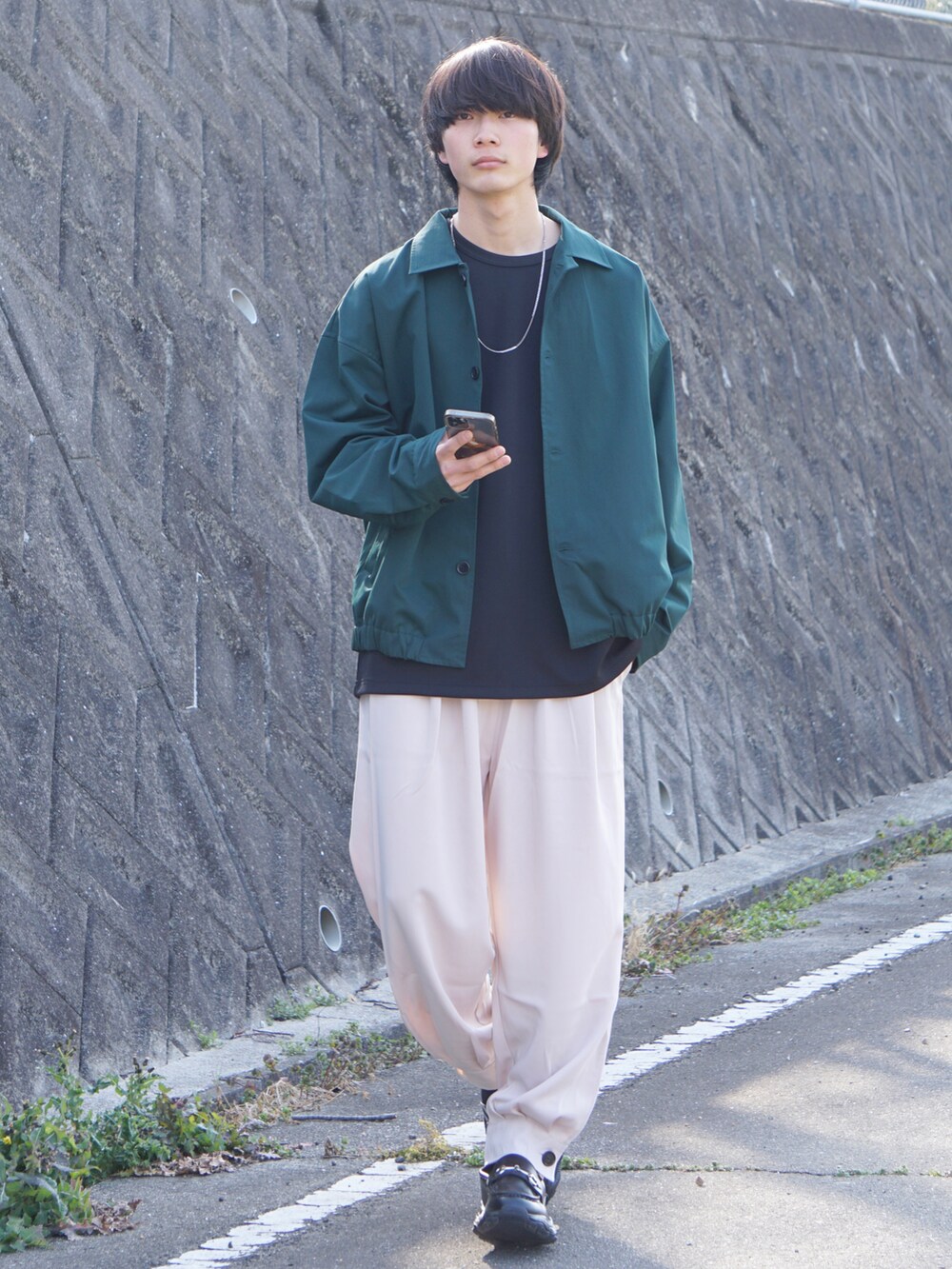 グリーン系のその他アウター、ブラック系のTシャツ/カットソー、ベージュ系のその他パンツを着用したメンズの春コーディネートの3枚目の写真