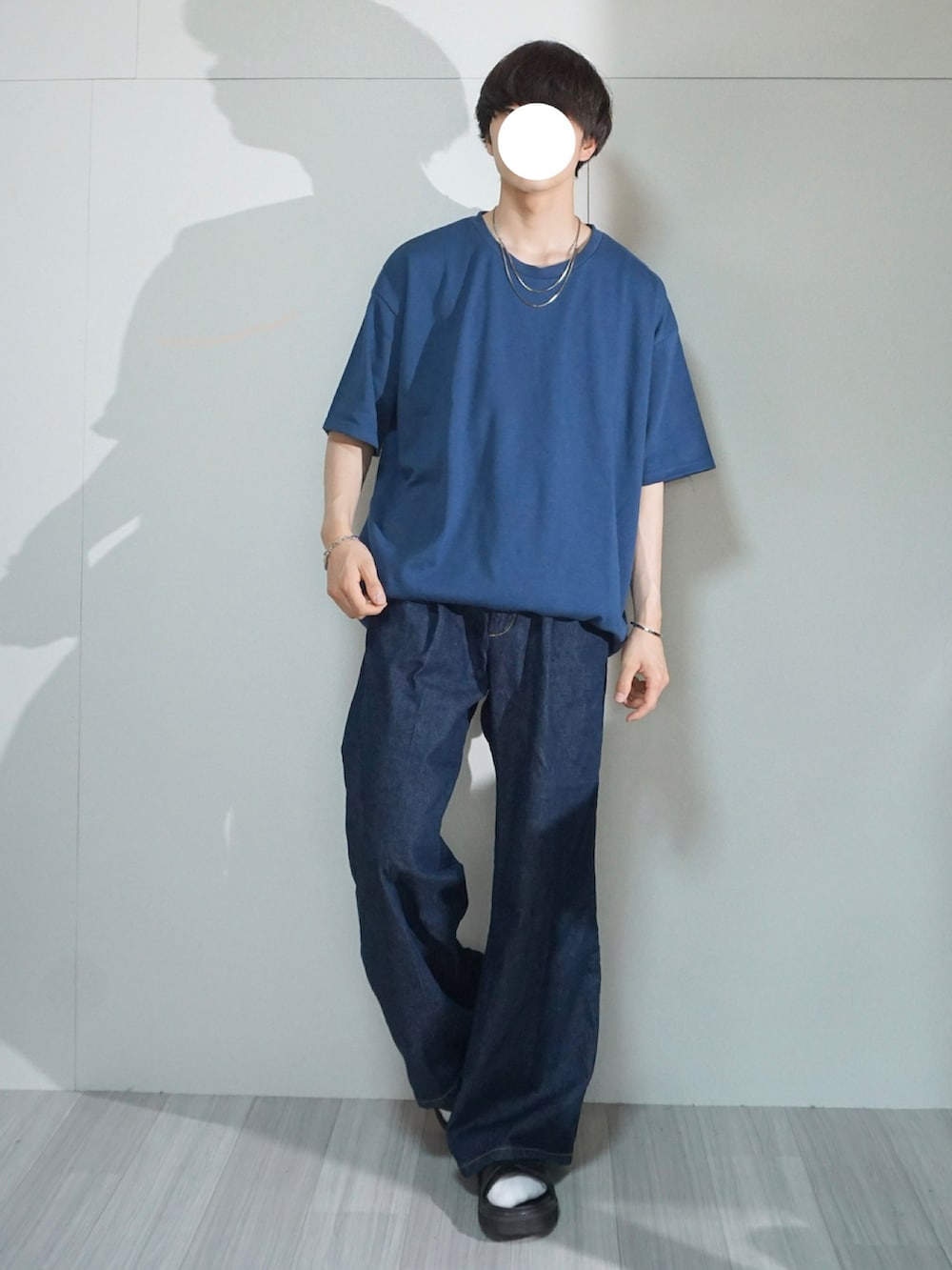 ブルー系のデニムパンツ、ブルー系のTシャツ/カットソー、ブラック系のサンダルを着用したメンズの春コーディネートの2枚目の写真