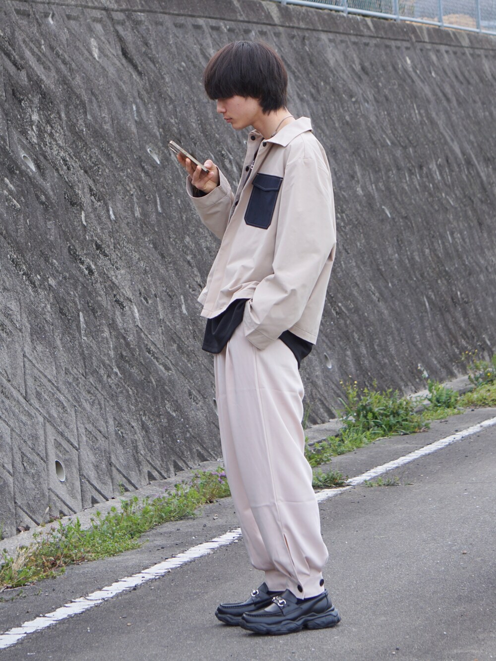 ベージュ系のブルゾン、ブラック系のTシャツ/カットソー、ベージュ系のその他パンツを着用したメンズの春コーディネートの3枚目の写真