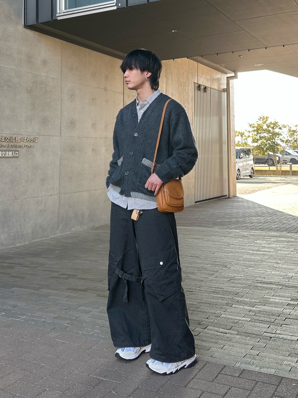 グレー系のカーディガン/ボレロ、ブラック系のカーゴパンツ、ホワイト系のスニーカーを着用したメンズの冬コーディネートの2枚目の写真