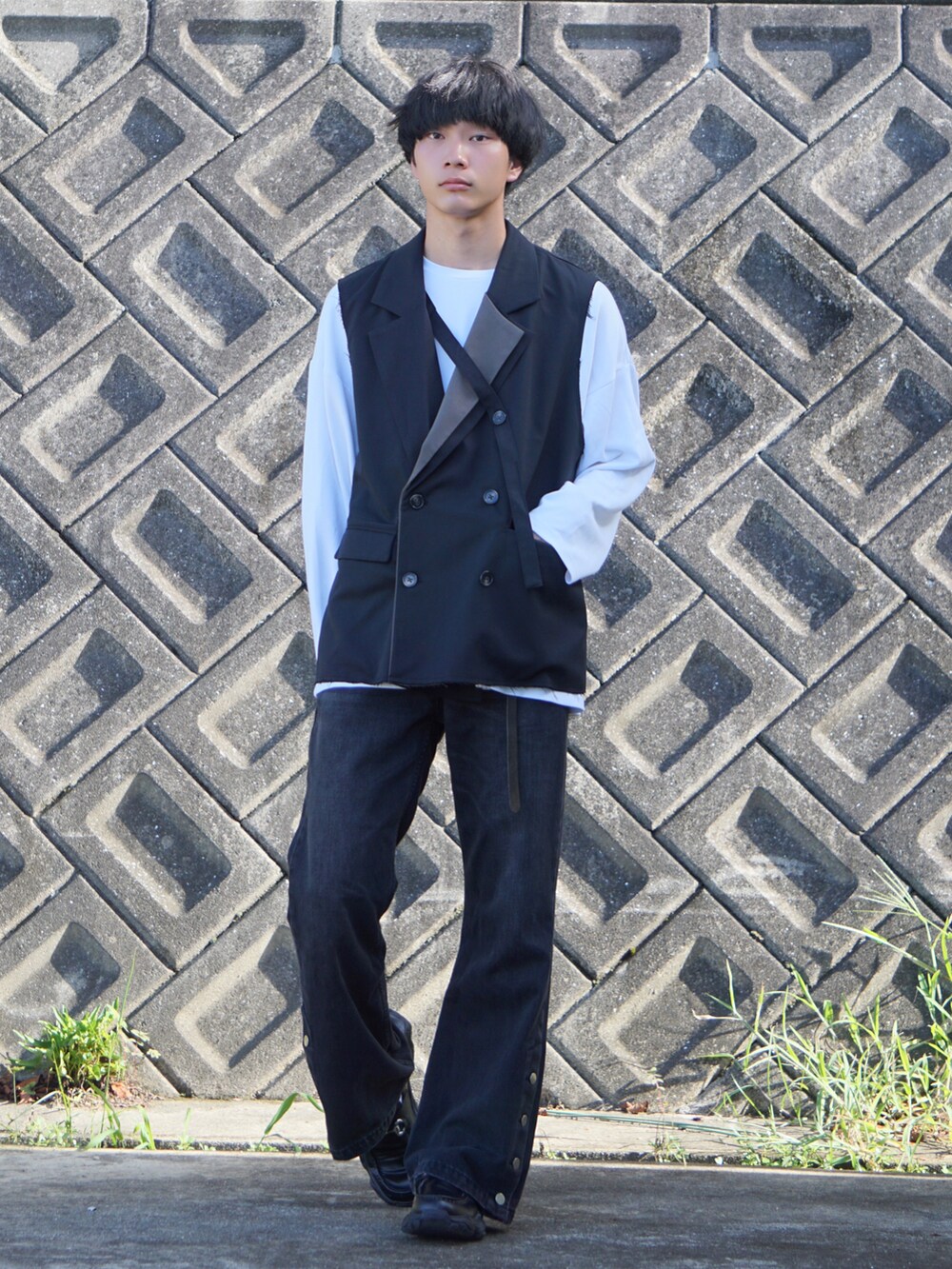 ブラック系のベスト、ホワイト系のTシャツ/カットソー、ブラック系のデニムパンツを着用したメンズの秋コーディネートの2枚目の写真