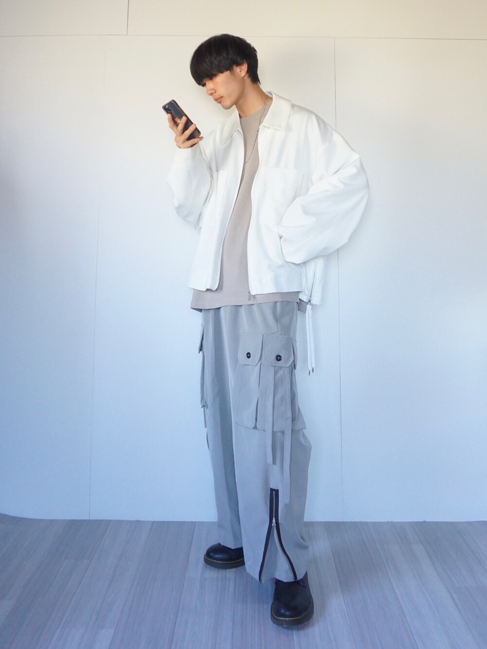 ベージュ系のTシャツ/カットソー、ホワイト系のブルゾン、グレー系のカーゴパンツを着用したメンズの秋コーディネートの2枚目の写真