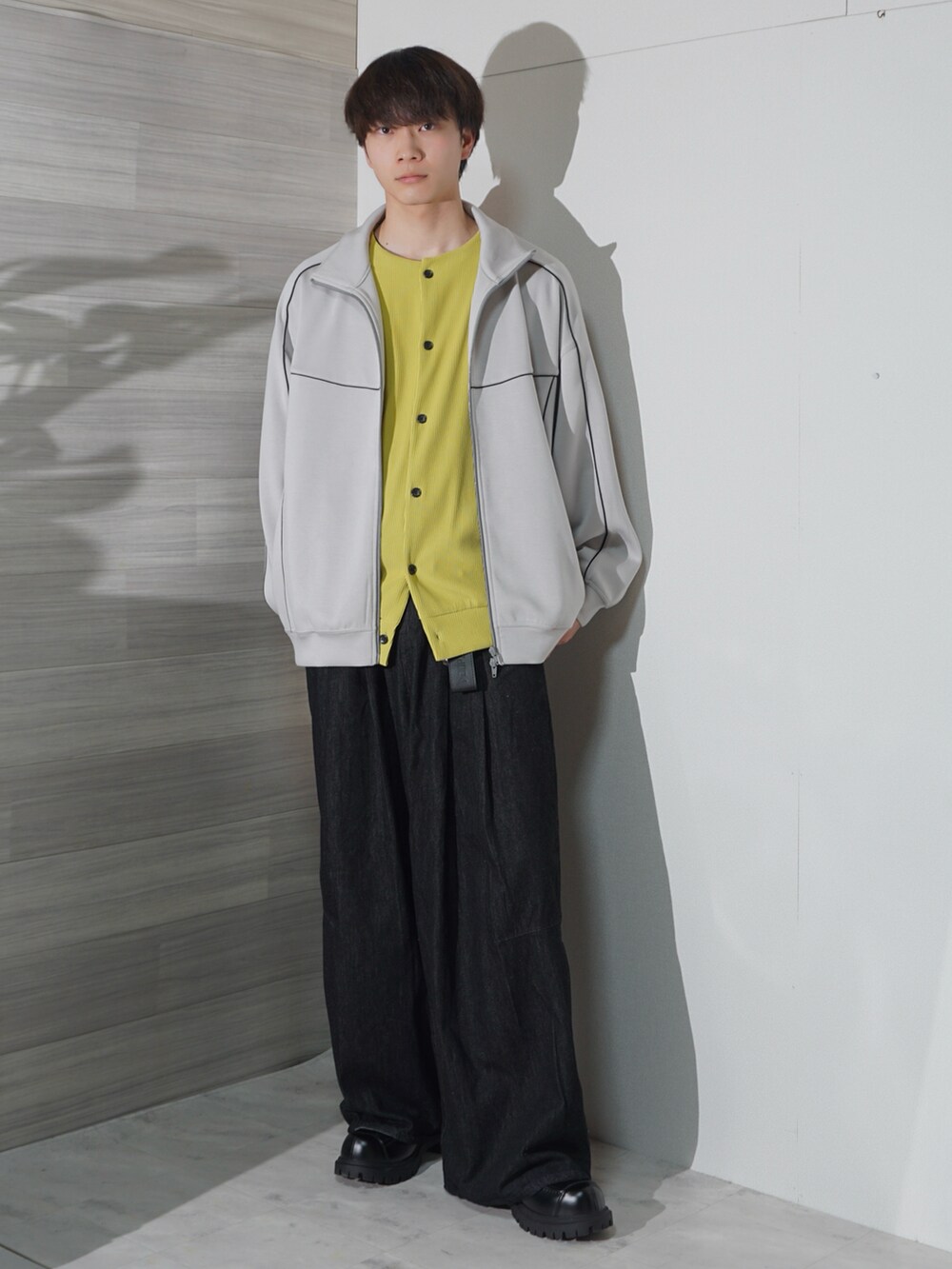 ホワイト系のブルゾン、ブラック系のデニムパンツ、イエロー系のカーディガン/ボレロを着用したメンズの春コーディネートの2枚目の写真