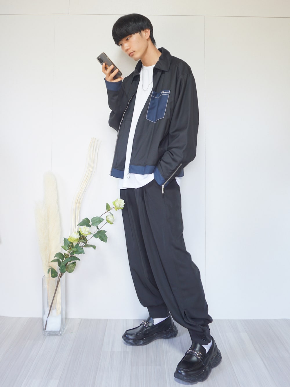 ブラック系のブルゾン、ホワイト系のTシャツ/カットソー、ブラック系のその他パンツを着用したメンズの秋コーディネートの2枚目の写真