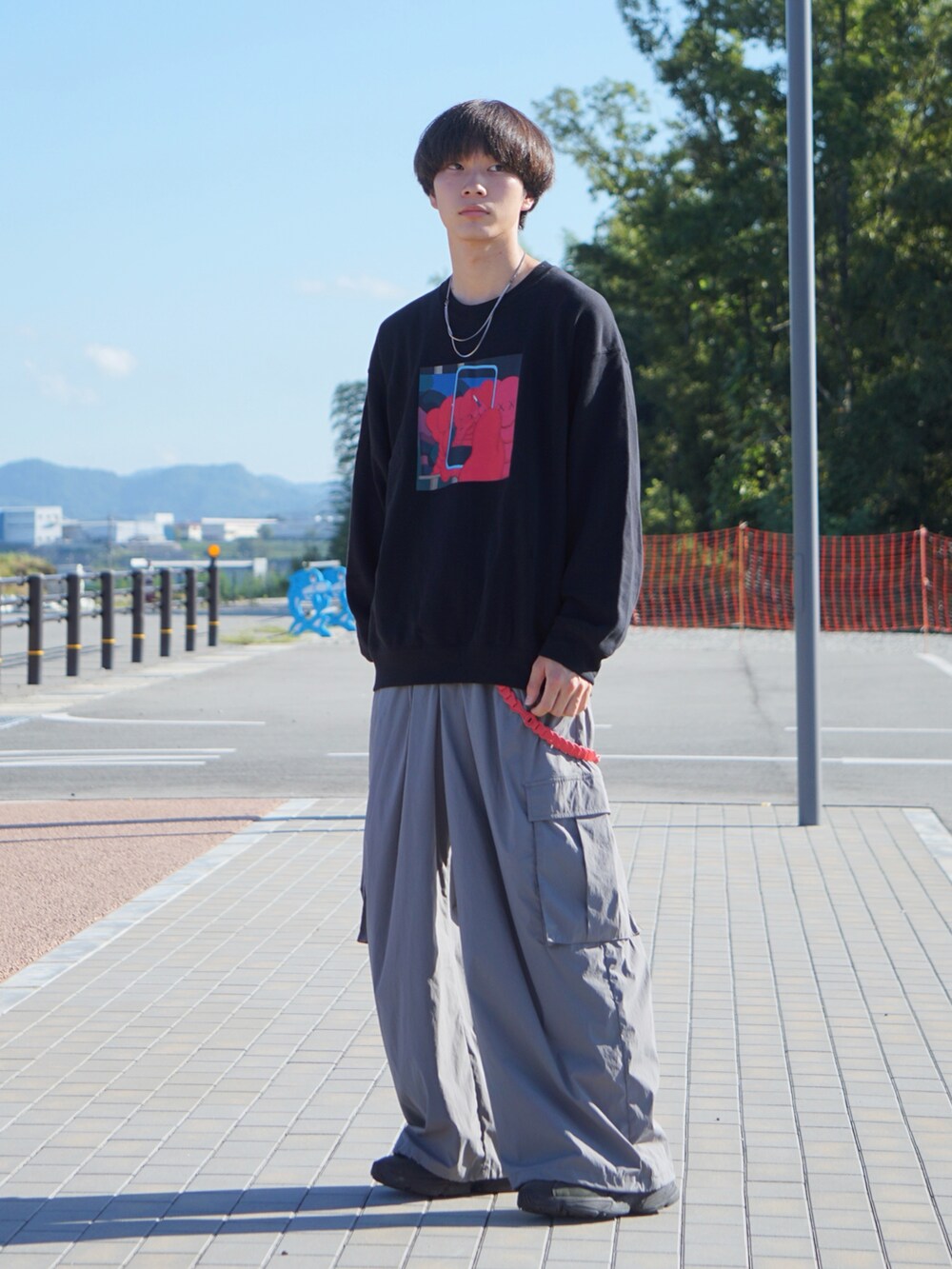 グレー系のカーゴパンツ、ブラック系のスニーカー、ブラック系のスウェットを着用したメンズの秋コーディネートの2枚目の写真