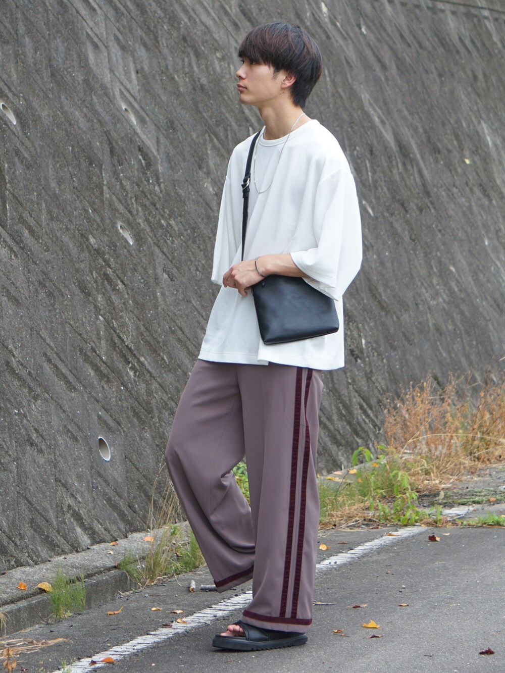 ブラック系のショルダーバッグ、ホワイト系のTシャツ/カットソー、ブラウン系のその他パンツを着用したメンズの夏コーディネートの2枚目の写真