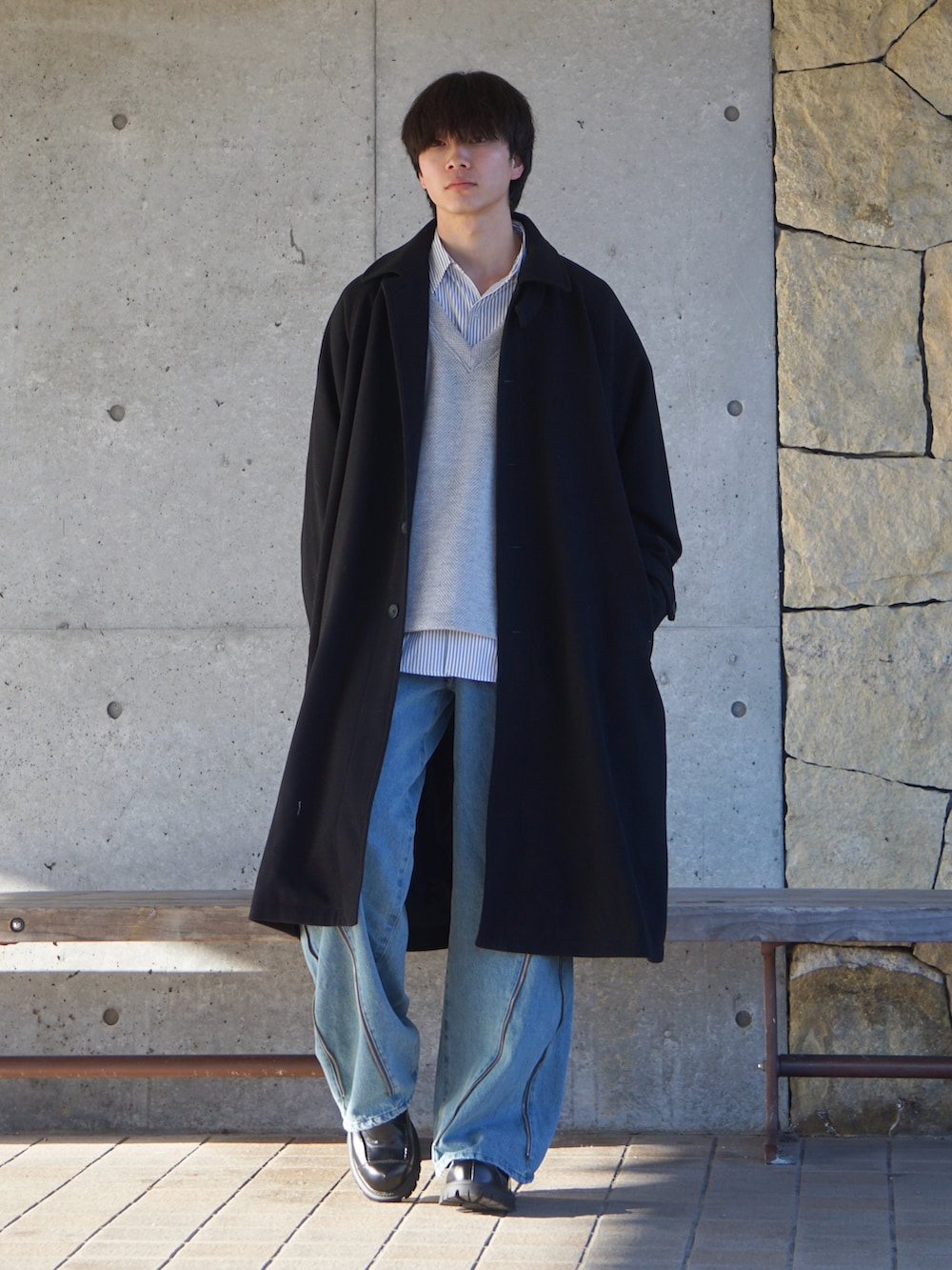 ブラック系のステンカラーコート、グレー系のシャツ/ブラウス、ホワイト系のスウェットを着用したメンズの冬コーディネートの2枚目の写真