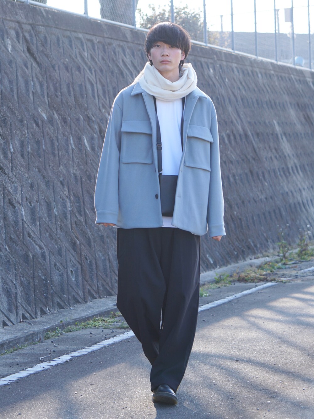 ブルー系のブルゾン、ホワイト系のTシャツ/カットソー、ブラック系のその他パンツを着用したメンズの冬コーディネートの2枚目の写真