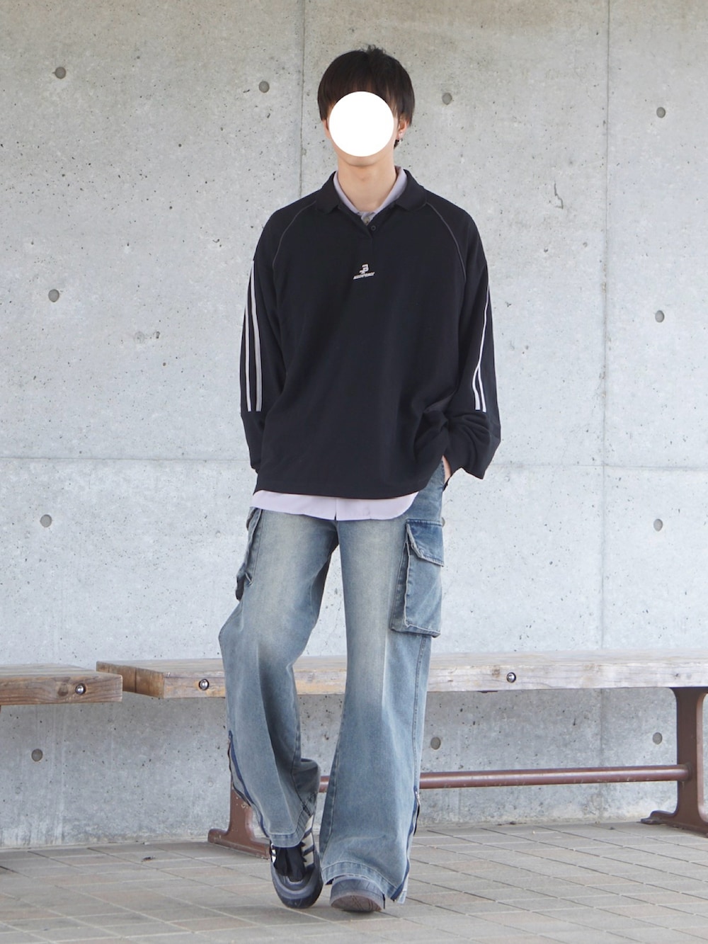 ブラック系のポロシャツ、ブルー系のカーゴパンツ、ブラック系のスニーカーを着用したメンズの春コーディネートの2枚目の写真