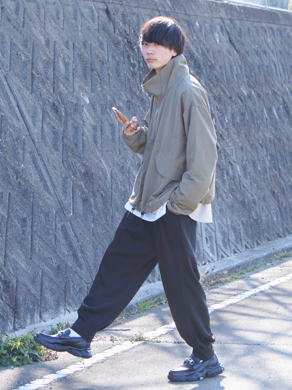 グリーン系のブルゾン、ベージュ系のシャツ/ブラウス、ホワイト系のTシャツ/カットソーを着用したメンズの冬コーディネートの2枚目の写真