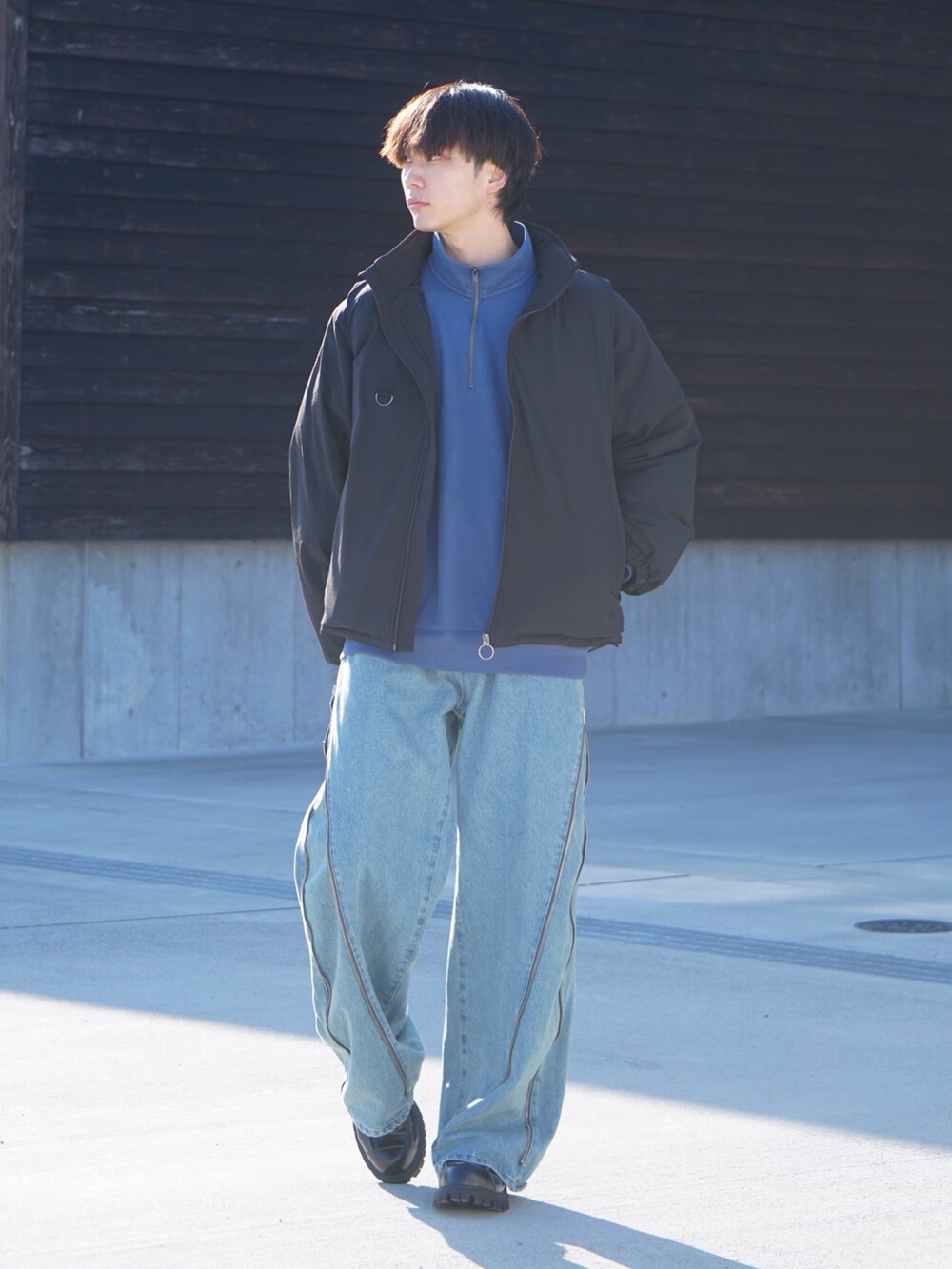 ブラック系のブルゾン、ブルー系のトップス、ブルー系のデニムパンツを着用したメンズの冬コーディネートの2枚目の写真