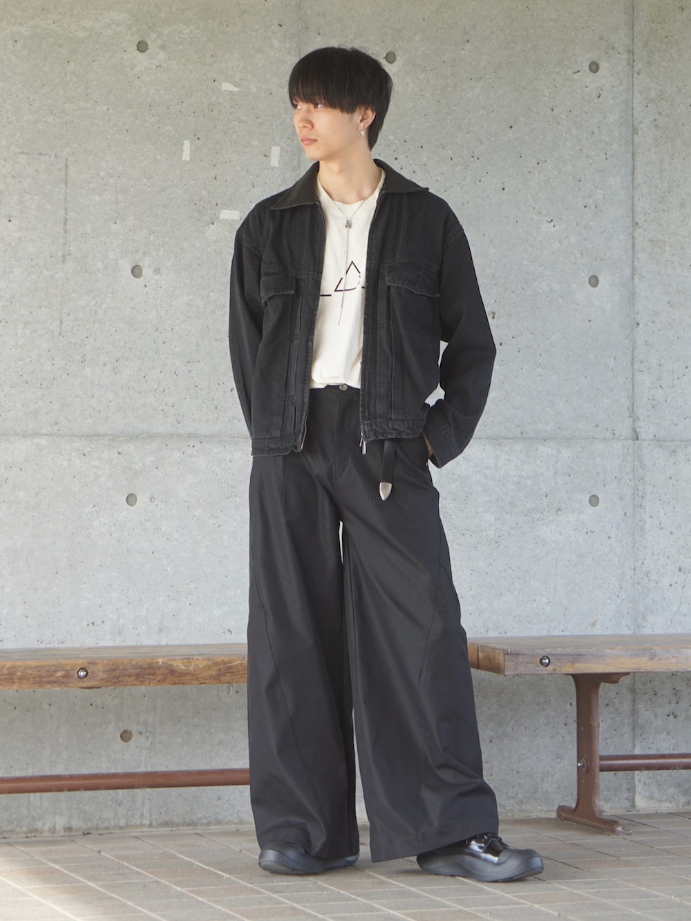 ベージュ系のTシャツ/カットソー、ブラック系のデニムジャケット、ブラック系のスラックスを着用したメンズの秋コーディネートの2枚目の写真