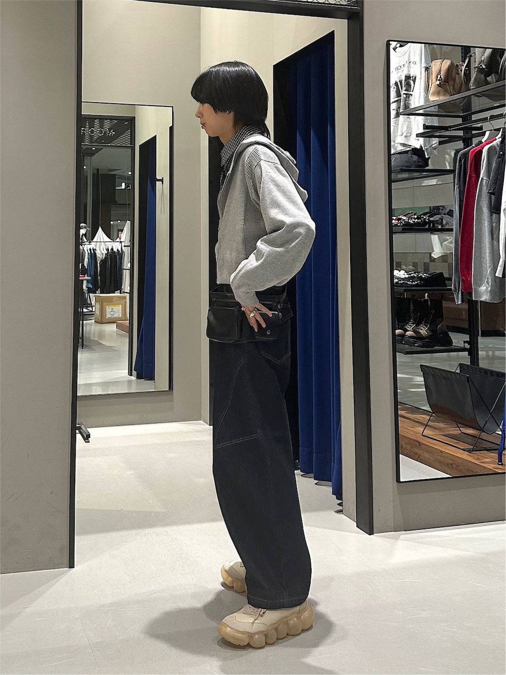グレー系のパーカー、ブルー系のデニムパンツ、ブラック系のボディバッグ/ウエストポーチを着用したメンズの秋コーディネートの3枚目の写真