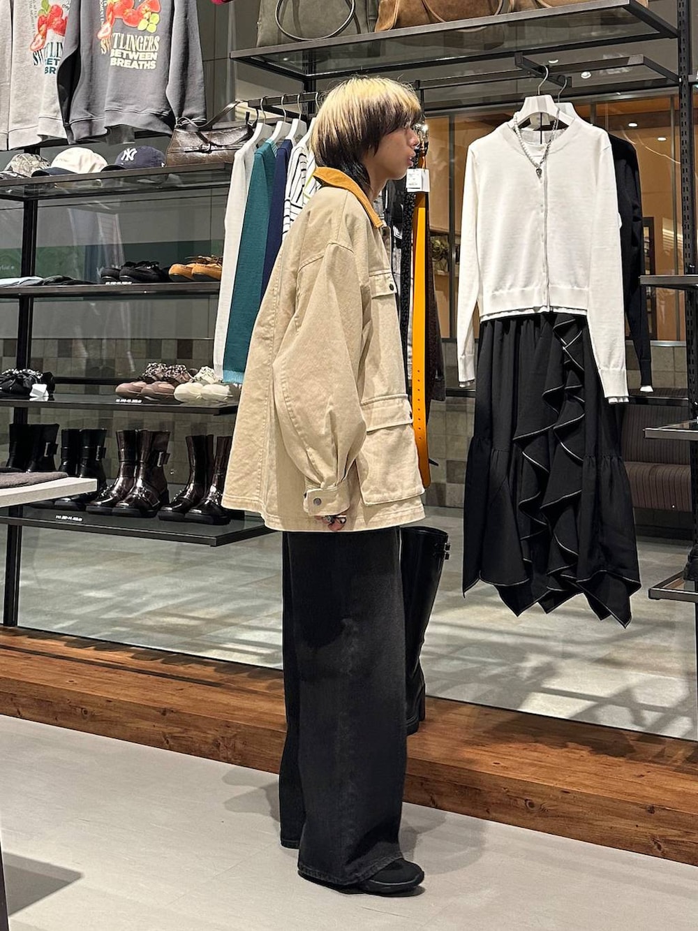 ブラック系のスラックス、ブラック系のスニーカー、ホワイト系のその他アウターを着用したメンズの冬コーディネートの4枚目の写真