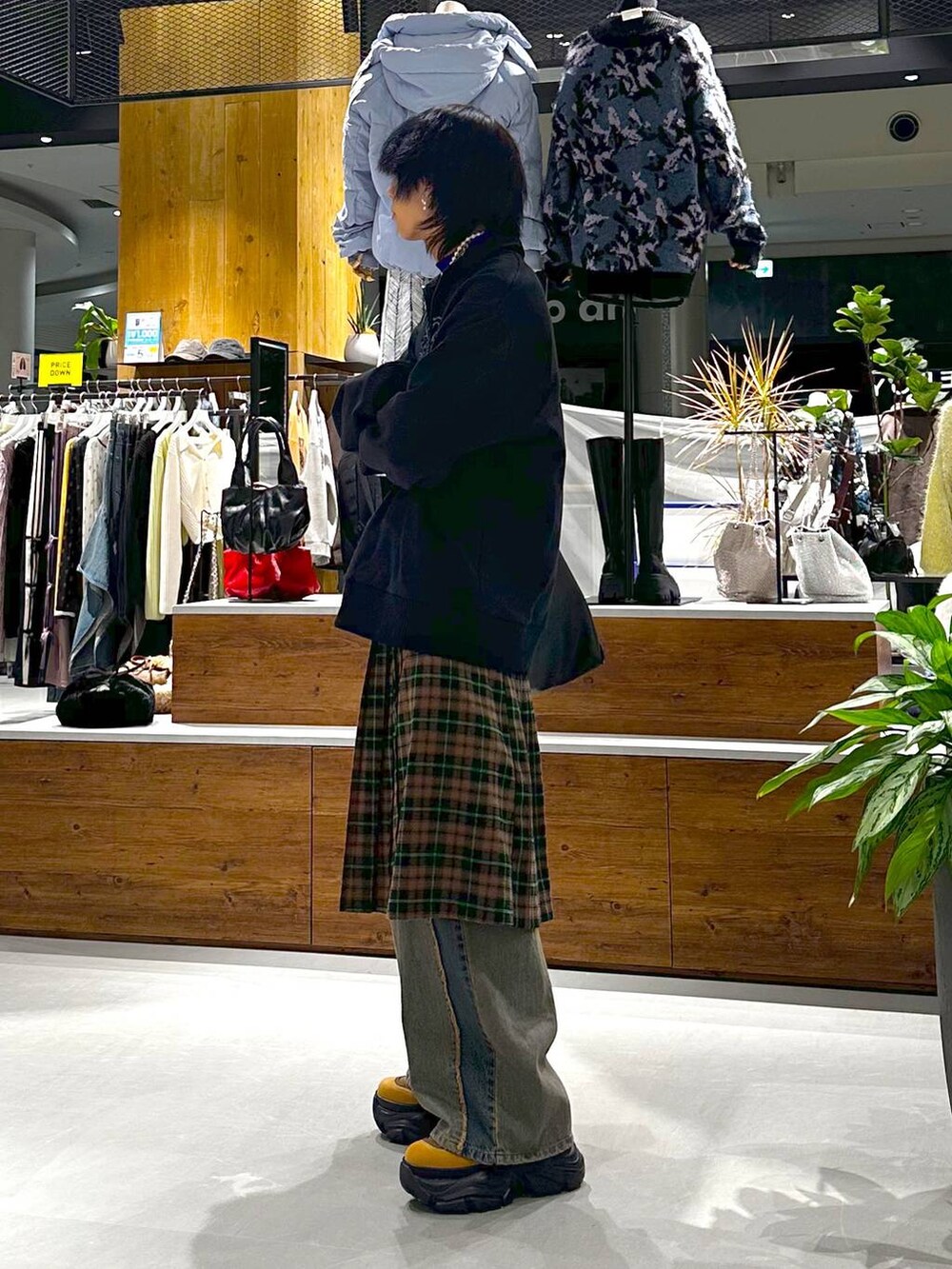 ブルー系のデニムパンツ、ブラウン系のブーツ、ブラック系のトートバッグを着用したメンズの秋コーディネートの4枚目の写真