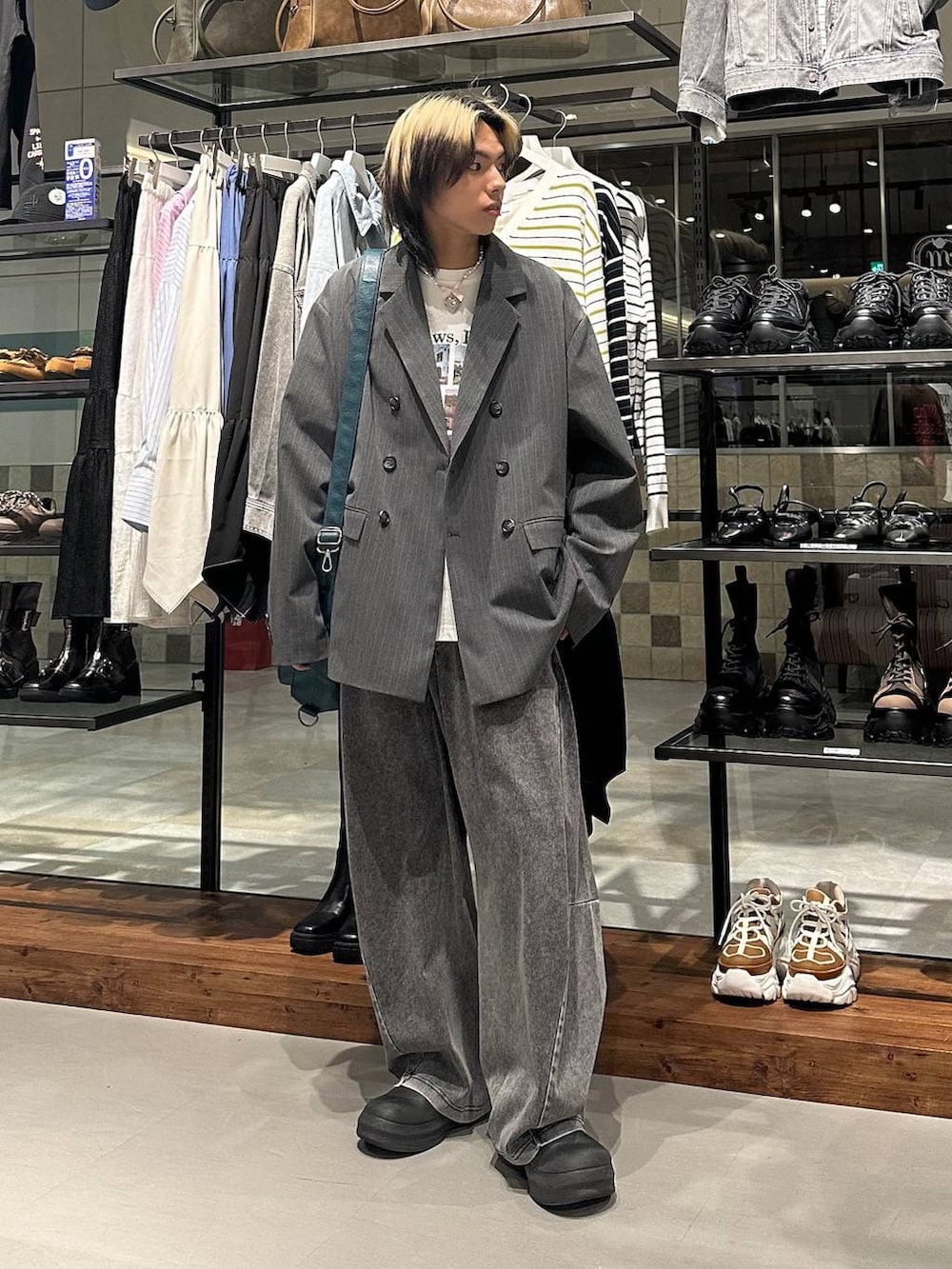 ブルー系のショルダーバッグ、ブラック系のデニムパンツ、ホワイト系のTシャツ/カットソーを着用したメンズの春コーディネートの2枚目の写真