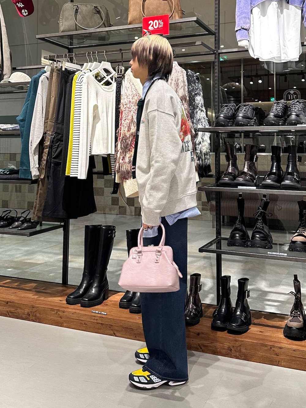 ブルー系のスラックス、ピンク系のハンドバッグ、グレー系のスウェットを着用したメンズの冬コーディネートの4枚目の写真