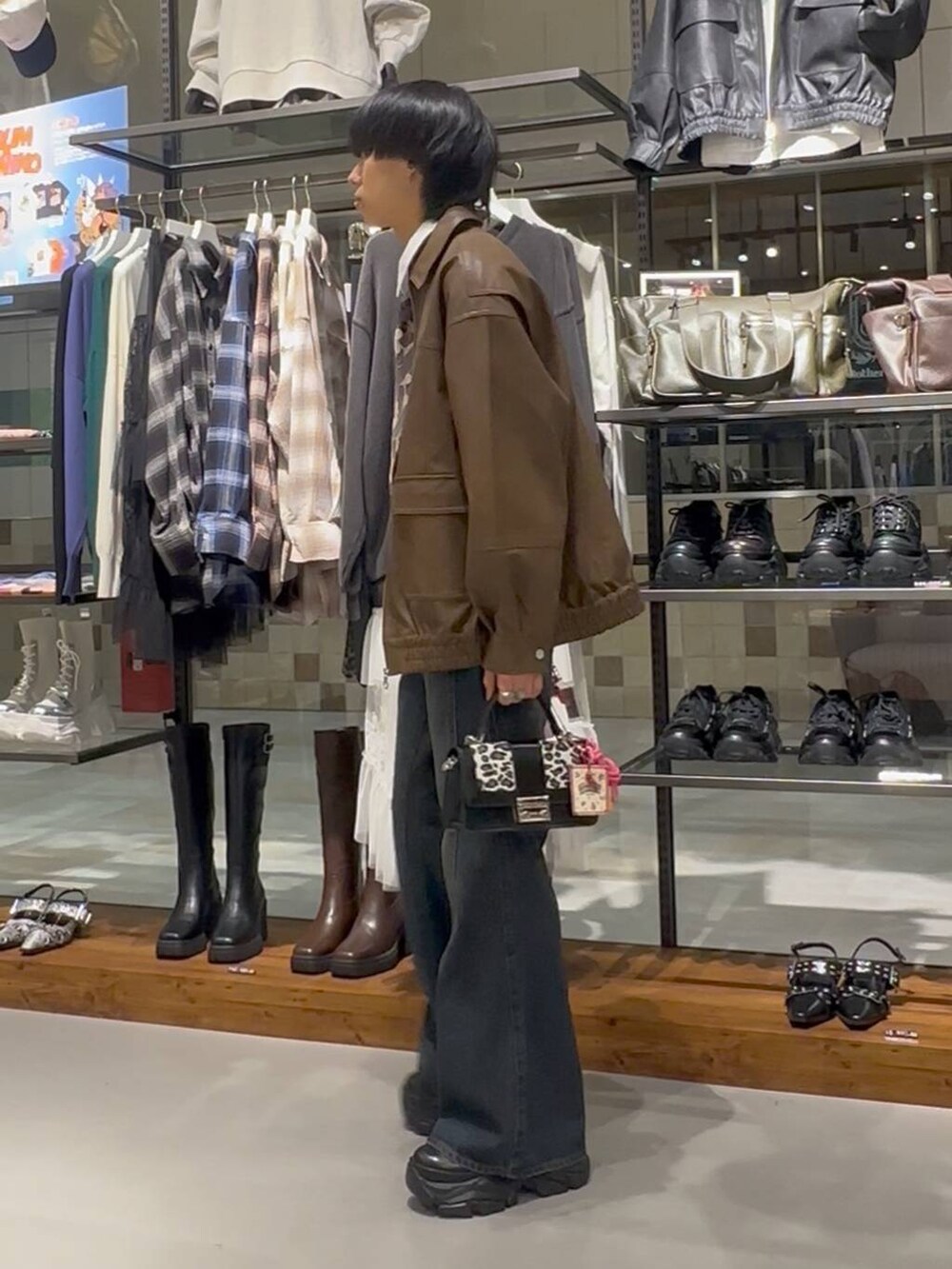 ブルー系のデニムパンツ、その他のハンドバッグ、ブラウン系のブルゾンを着用したメンズの秋コーディネートの3枚目の写真