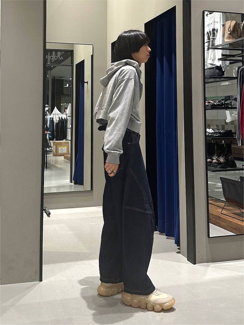 グレー系のパーカー、ブルー系のデニムパンツ、ブラック系のボディバッグ/ウエストポーチを着用したメンズの秋コーディネートの4枚目の写真