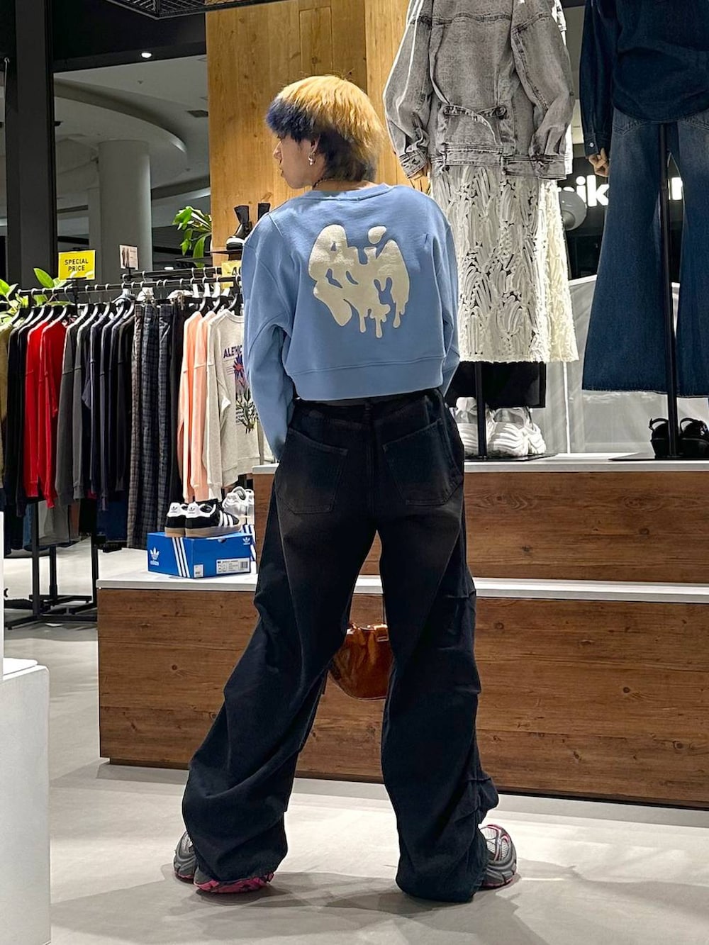 ブルー系のデニムパンツ、ブルー系のスウェット、ブラウン系のショルダーバッグを着用したメンズの春コーディネートの5枚目の写真