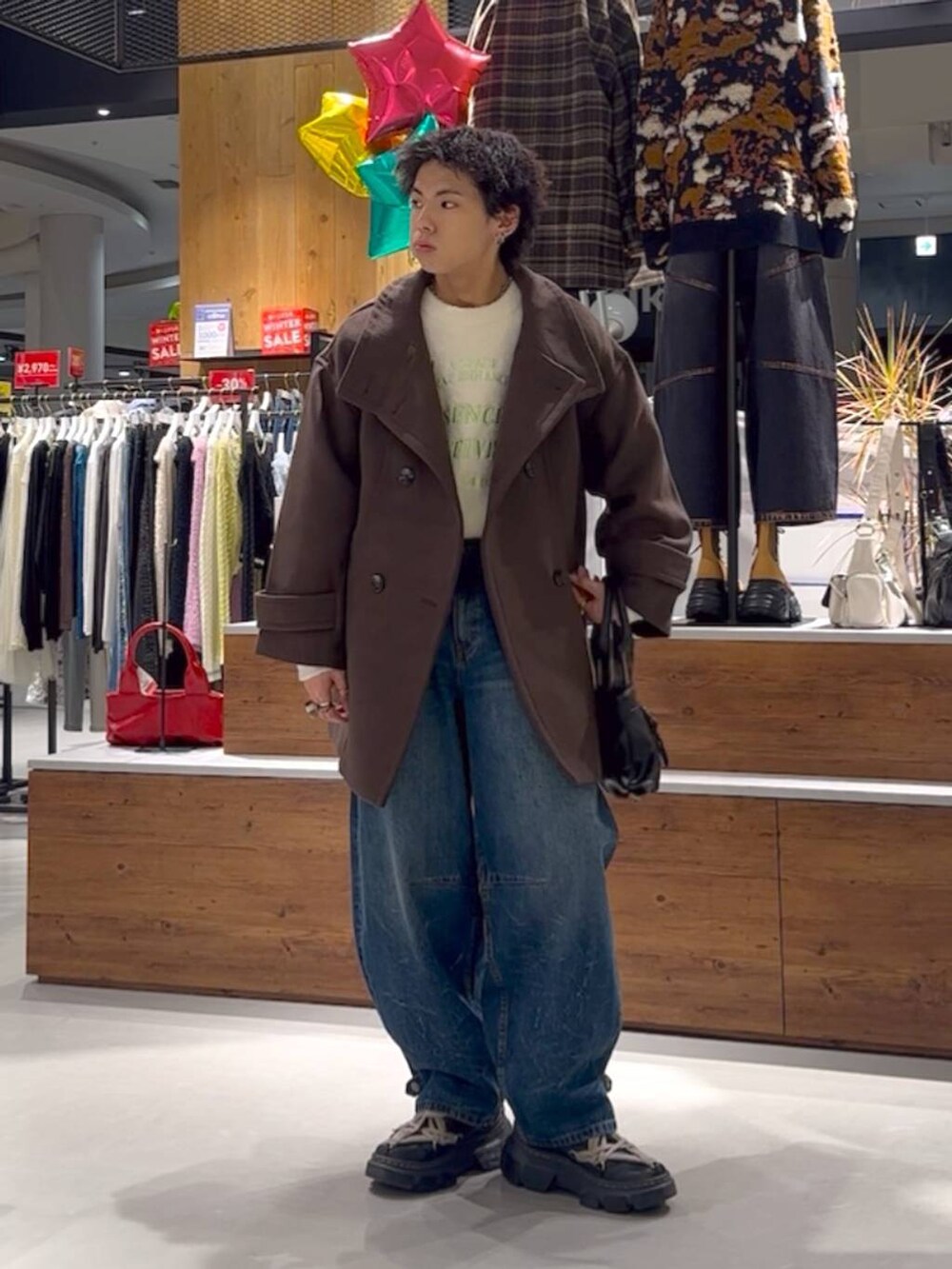 ホワイト系のニット/セーター、ブラウン系のテーラードジャケット、ブルー系のデニムパンツを着用したメンズの冬コーディネートの2枚目の写真