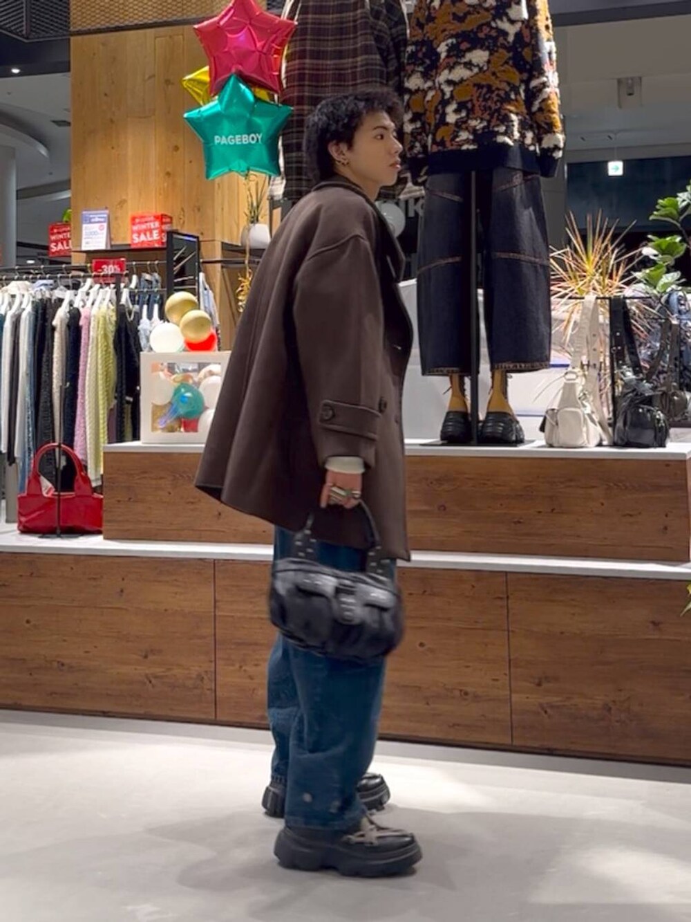 ホワイト系のニット/セーター、ブラウン系のテーラードジャケット、ブルー系のデニムパンツを着用したメンズの冬コーディネートの3枚目の写真