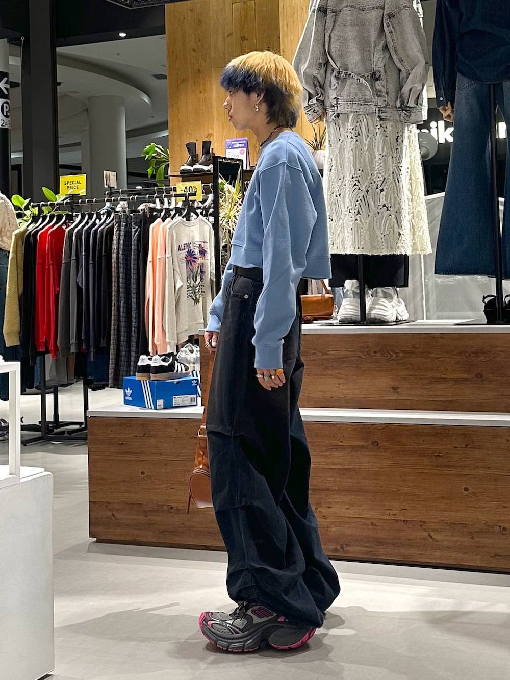 ブルー系のデニムパンツ、ブルー系のスウェット、ブラウン系のショルダーバッグを着用したメンズの春コーディネートの3枚目の写真