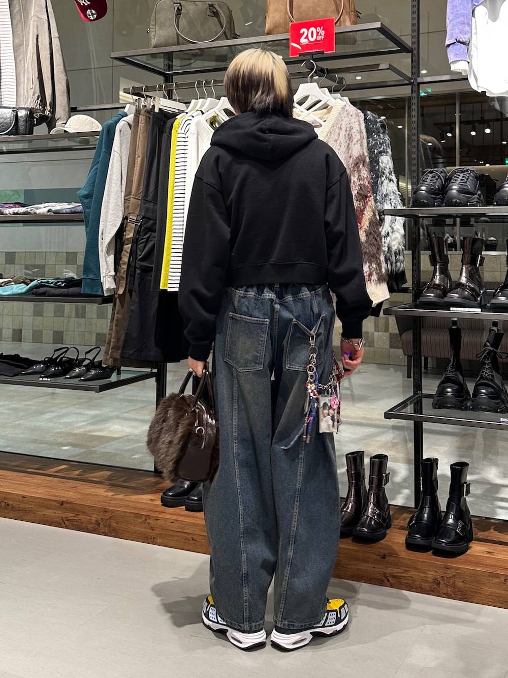 ブラウン系のボストンバッグ、ブルー系のデニムパンツ、ブラック系のパーカーを着用したメンズの冬コーディネートの5枚目の写真