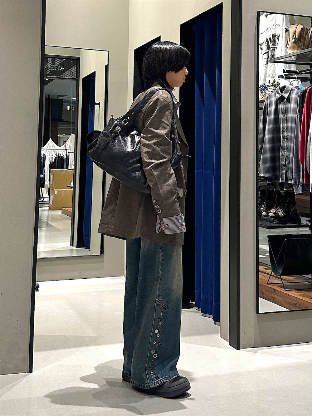 ブラック系のトートバッグ、ブルー系のデニムパンツ、グレー系のシャツ/ブラウスを着用したメンズの秋コーディネートの3枚目の写真