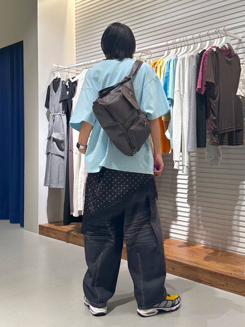 ブラック系のチュニック、ブラウン系のショルダーバッグ、ブラック系のデニムパンツを着用したメンズの夏コーディネートの5枚目の写真