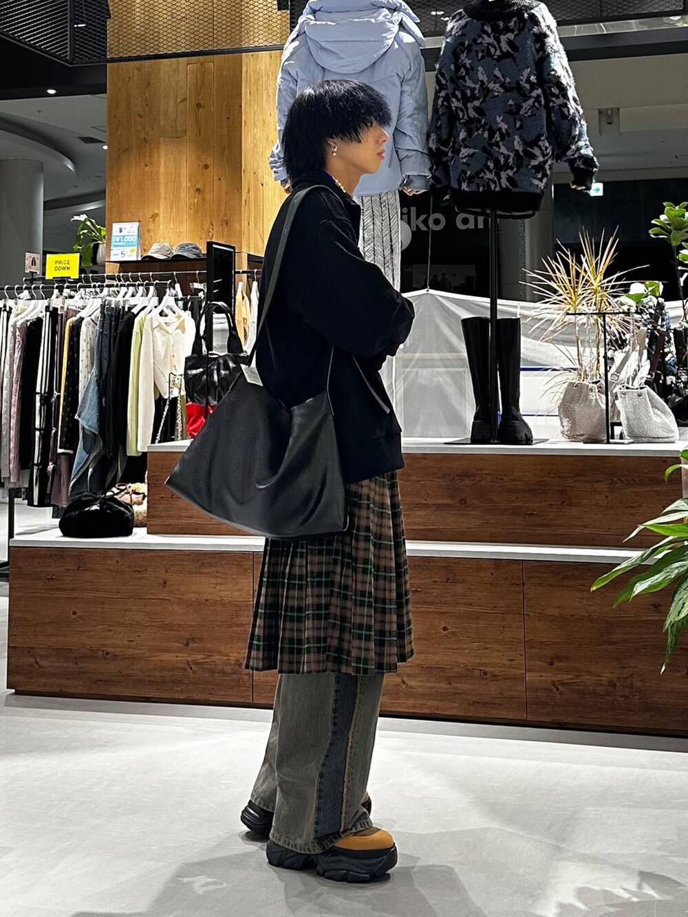 ブルー系のデニムパンツ、ブラウン系のブーツ、ブラック系のトートバッグを着用したメンズの秋コーディネートの3枚目の写真