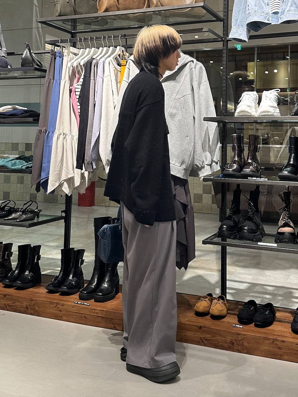 グレー系のデニムパンツ、ブルー系のショルダーバッグ、ブラック系のカーディガン/ボレロを着用したメンズの冬コーディネートの3枚目の写真